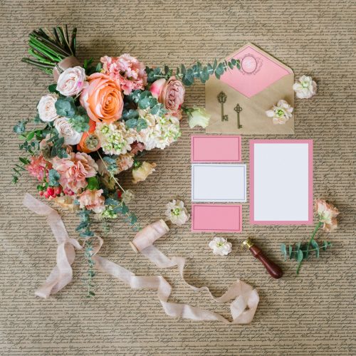 Workspace. Wedding invitations, envelopes, pink and bouquet rose